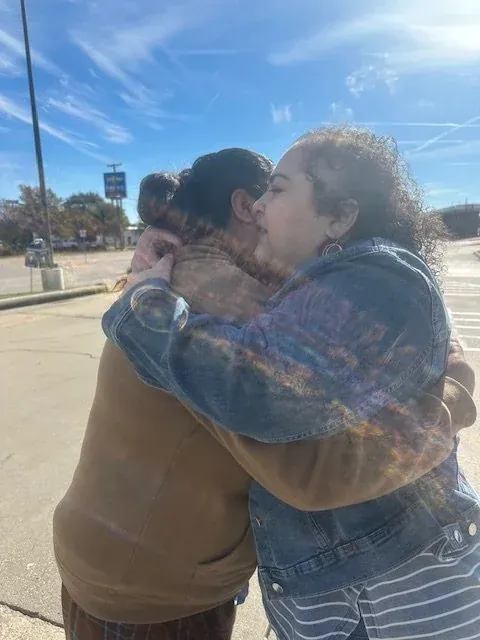 Melissa embracing a woman at an outreach